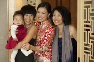 Chinese bride smiling in a group picture with a toddler and female friends