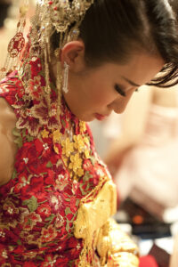 Bride wearing red floral Chinese outfit with gold jewellery