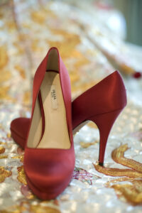 Red silk Prada court shoes sitting a top a mint and gold Chinese dress