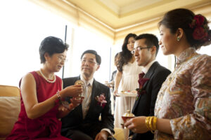 Bride and groom serving tea to family during tea ceremony