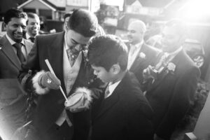 Black and white picture of groom eating food from a bowl with chopsticks