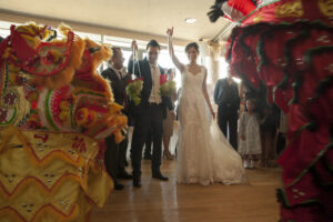 Bride and groom offering traditional items to gold and red Chinese dragons