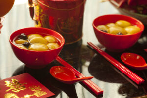 Red bowls of food with red envelopes and red chopsticks