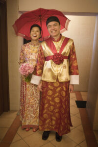 Groom and bride under a red umbrella