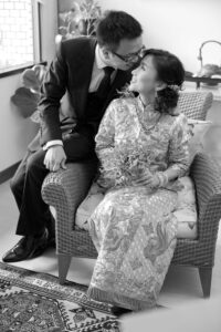 Bride sitting on the chair with groom kissing head