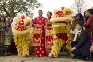 Bride and groom in the middle of the photograph surrounded by 2 gold dragons and family members