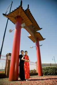 Bride and groom standing under a traditional Chinese archway